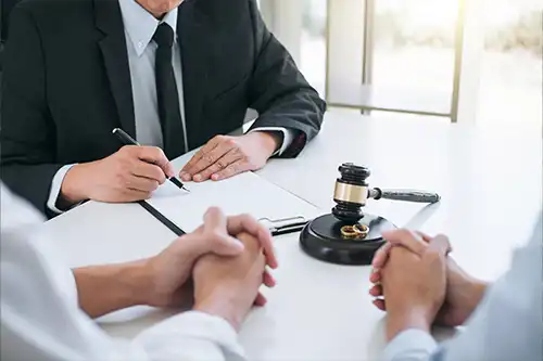 Michael A. Hankins Attorney at Law—A lawyer sits with a couple to discuss their divorce in an office in Jacksonville, IL.